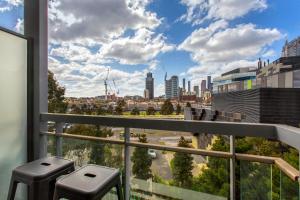 a view of a city from a balcony with stools at Docklands Private Collection - Digital Harbour in Melbourne