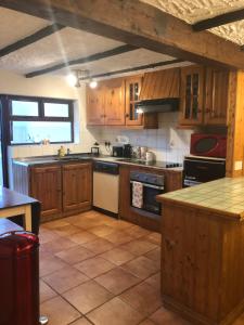 eine Küche mit Holzschränken und einer Arbeitsplatte in der Unterkunft NEW LISTING Faye’s Place in Donegal