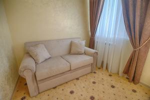 a living room with a couch in front of a window at Hotel Grand Yelets in Yelets
