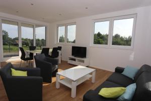 a living room with a couch and chairs and a table at Villa Wasser in Hörstel