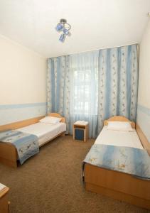 une chambre avec deux lits et une fenêtre dans l'établissement Zhemchuzhina Kavkaza Hotel, à Jeleznovodsk