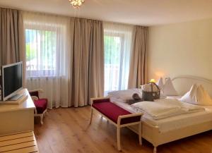 Schlafzimmer mit einem Bett und einem Schreibtisch mit einem TV in der Unterkunft Hotel Stefanshof in Plaus