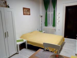 a small room with a yellow bed in it at Studio Jolie in Novi Sad