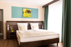 Un pat sau paturi într-o cameră la Parkhotel Herne