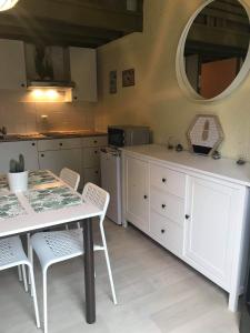 uma cozinha com uma mesa, cadeiras e um espelho em Loft rénové au calme à la campagne pour famille em Hastière-par-delà