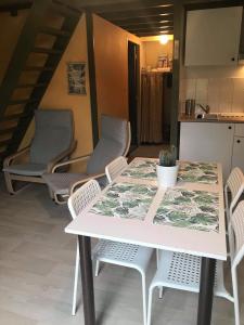 uma mesa branca e cadeiras numa cozinha em Loft rénové au calme à la campagne pour famille em Hastière-par-delà