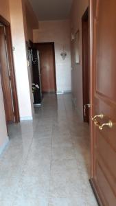 an empty hallway with a door and a tile floor at Casa Vacanze nel Verde a 5 Km dal mare in Nettuno