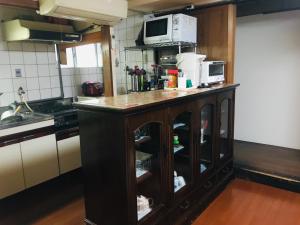 a kitchen with a counter with a microwave on top at Guest Inn Chita in Kyoto