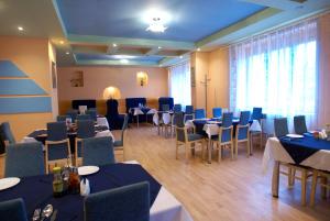 a dining room with tables and chairs with blue tables and chairsktop at Europa in Rakhiv