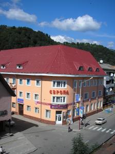 a large building with a red roof on a street at Europa in Rakhiv