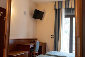 a room with a bed and a desk and a window at Garda Family House in Brenzone sul Garda