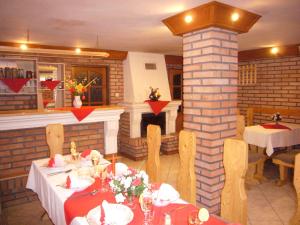 a restaurant with tables and chairs and a fireplace at Penzión u Peťa in Hruštín