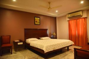 1 dormitorio con cama y cortina roja en Hotel Subhalakshmi Palace, en Kāraikkudi