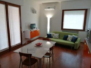 een woonkamer met een groene bank en een tafel bij Casa Pinna in Càbras