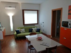 een woonkamer met een groene bank en een tafel bij Casa Pinna in Càbras