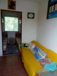 a living room with a yellow couch and a window at U Novomlýnské nádrže in Nové Mlýny