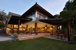 a house with a patio with tables and chairs at Puri Saron Hotel Baruna Beach Lovina in Lovina +44 photos