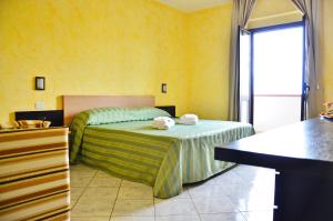 1 dormitorio con 1 cama en una habitación amarilla en Hotel Onda Bleu, en Botricello