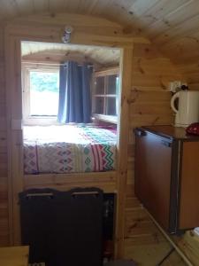 a small bedroom with a bed in a log cabin at Ma KaBane in Couvains