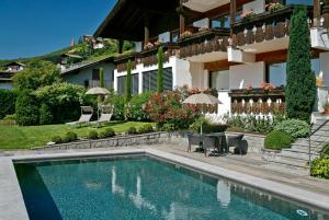 une maison avec une piscine en face d'une maison dans l'établissement Egger Apartments, à Rifiano