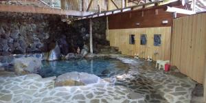 a large pool of water in a room with rocks at Kappa Tengoku in Hakone +39 photos