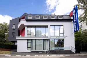 een wit gebouw met een blauw bord erop bij Hotel Alex in Galaţi