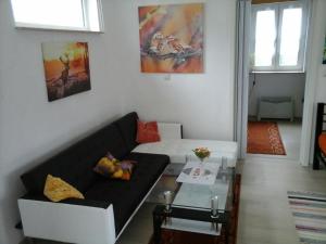 ein Wohnzimmer mit einem schwarzen Sofa und einem Tisch in der Unterkunft Ferienhaus Günther Werder-Havel in Werder