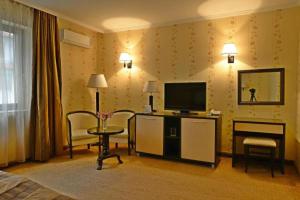 ein Hotelzimmer mit einem Bett und einem TV in der Unterkunft Merian Palace Hotel in Stara Sagora