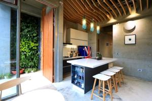 a kitchen with a counter and stools in a room at 墾丁 住在Zhuzai in Checheng
