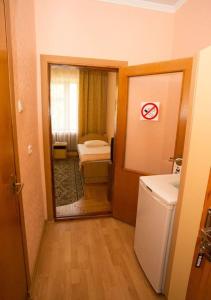 Cette petite chambre comprend un lit et un miroir. dans l'établissement Zhemchuzhina Kavkaza Hotel, à Jeleznovodsk 110 autres photos