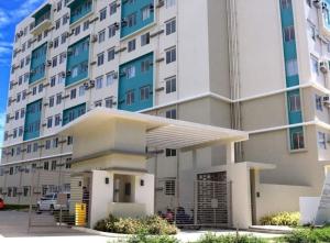 a large building with a parking lot in front of it at B2B Condo, MARINA SPATIAL - Dumaguete in Dumaguete