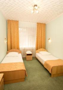 une chambre avec deux lits et un ventilateur de plafond dans l'établissement Zhemchuzhina Kavkaza Hotel, à Jeleznovodsk