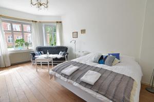 een slaapkamer met een groot bed en een stoel bij Struckshus in Tønder