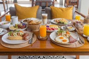 a table with plates of breakfast foods and orange juice at Princess Paradise Koh Phangan in Baan Khai