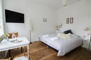 1 dormitorio con cama, mesa y TV en Struckshus en Tønder