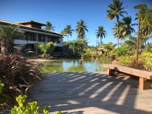 um banco num passadiço em frente a uma casa em Paraiso Praia de Imbassai - Ykutiba S-001 - Duplex frente mar em Imbassaí