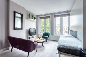 1 dormitorio con 1 cama, 1 silla y TV en Bed and Breakfast The Rose, en Haarlem