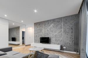 a living room with a tv on a wall at Apartament DeLux in Poznań