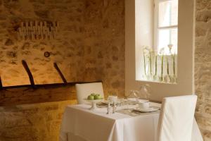 a white table with two chairs and a table with a white table cloth at S'Hotelet de Santanyi in Santanyi