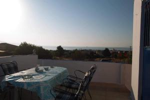 einen Tisch und Stühle auf einem Balkon mit Aussicht in der Unterkunft Airport View House in Artemida