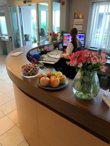 a woman sitting at a counter with food and flowers at Hotel Garni Max Zwo in Dingolfing