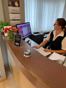 a woman sitting at a desk with a computer at Hotel Garni Max Zwo in Dingolfing