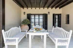 een witte tafel en stoelen op een patio bij Knossos Palace Secluded Villa in Skalánion