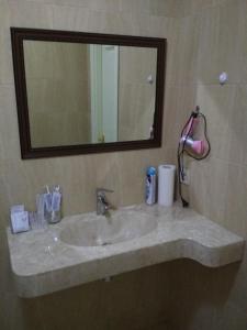 a bathroom with a sink with a mirror and a mirror at Hotel Elita in Odesa