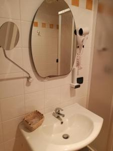 y baño con lavabo y espejo. en Hotel Dimora Adriana, en Tívoli
