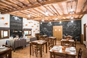 a restaurant with wooden tables and a chalkboard wall at Agriturismo La Valle Di Vico in Caprarola