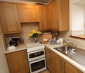 a kitchen with a sink and a stove top oven at Ystumgwern Luxury Barn Conversions in Dyffryn