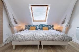 a bedroom with a bed with blue pillows and a window at Superbe Appartement - 3km DisneyLand et 20 min des JO in Magny-le-Hongre