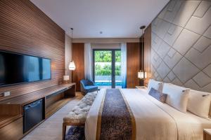 a hotel room with a large bed and a flat screen tv at Hard Rock Hotel Desaru Coast in Desaru