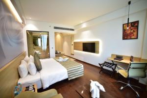 a hotel room with a bed and a desk at Nemesia City Center - Gurugram, Sector 29 in Gurgaon